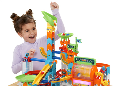 Child watches and cheers as the marbles race through the track.