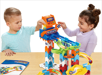 Two children placing marbles into the Starting Gate of the track.