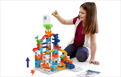 Child placing a marble into the funnel to see if tilting the set effects which side the marble rolls.