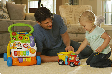 Parent with child playing with Drop & Go Dump Truck and Sit-to-Stand Learning Walker from VTech Parent with child playing with Drop & Go Dump Truck and Sit-to-Stand Learning Walker from VTech